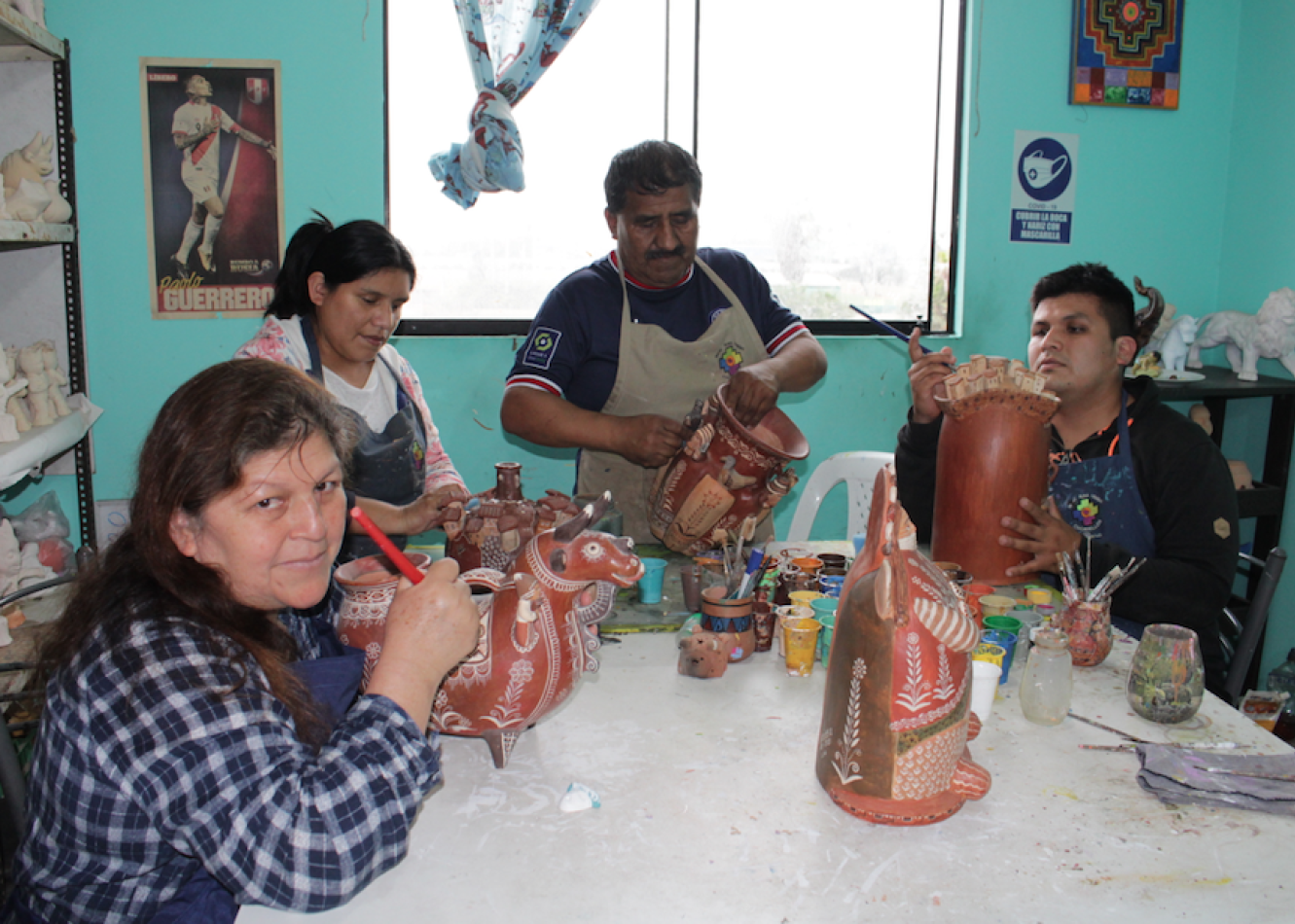 Leonidas Orellana, artista tradicional que lidera el Taller Wari Runa, enseñando la técnica del pintado de cerámica de Quinua.